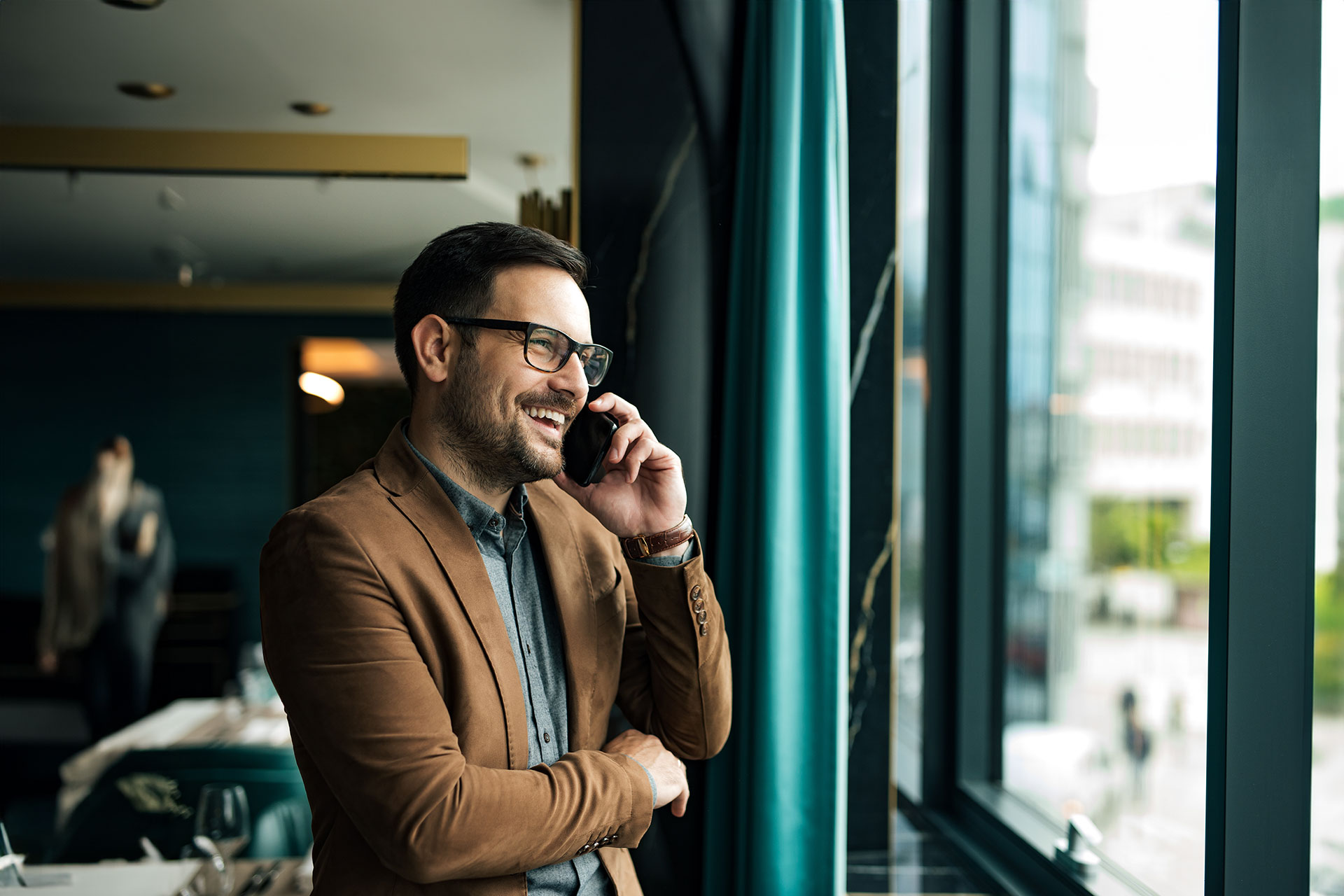 Man on phone looking out window